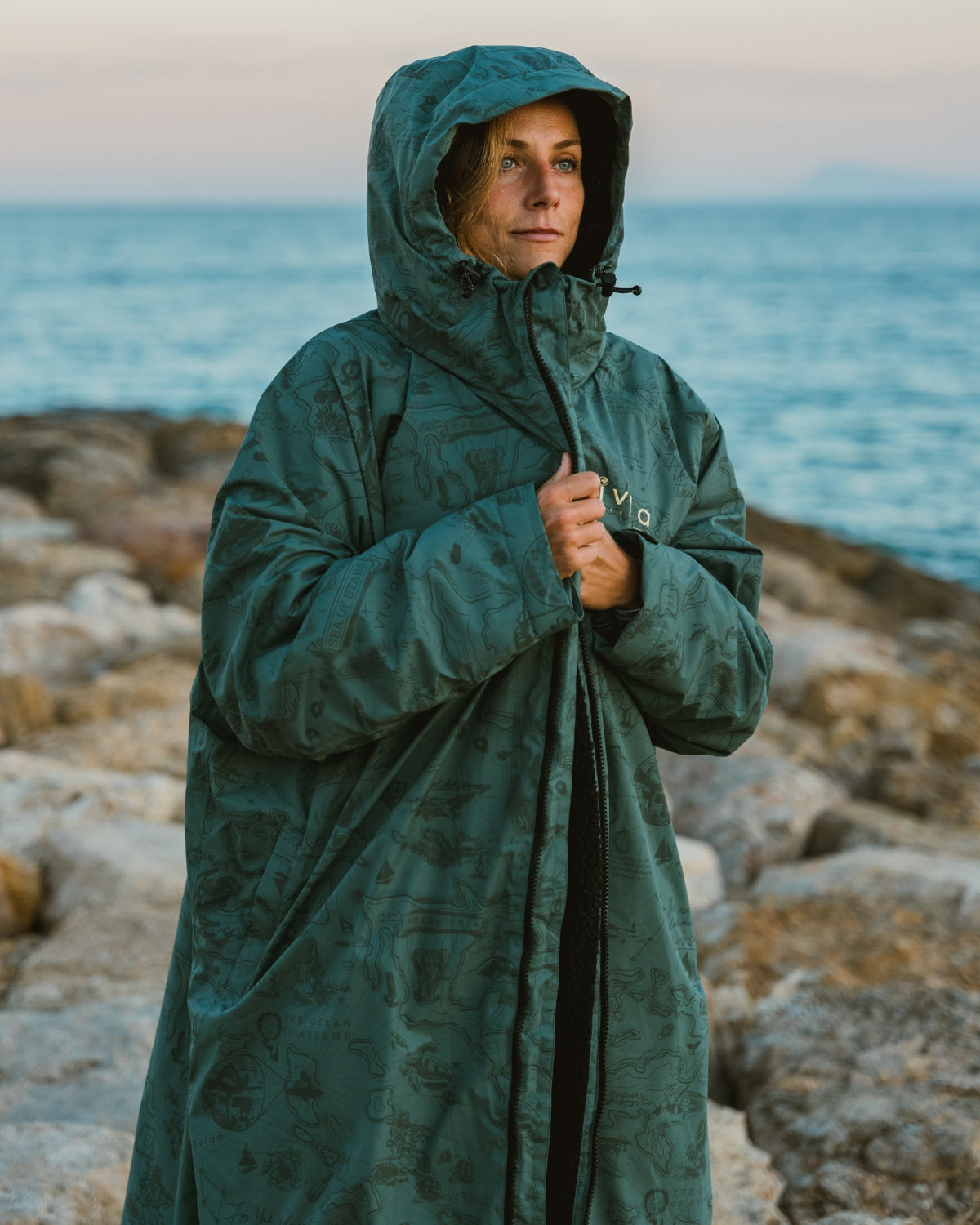 Lead_women - Woman wearing a Vivida sherpa weatherproof changing robe Green Map of Dreams