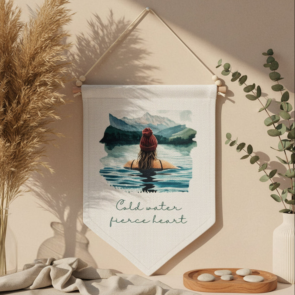 Fabric banner with a scenic design of a person in water and mountains, hanging on a beige wall.