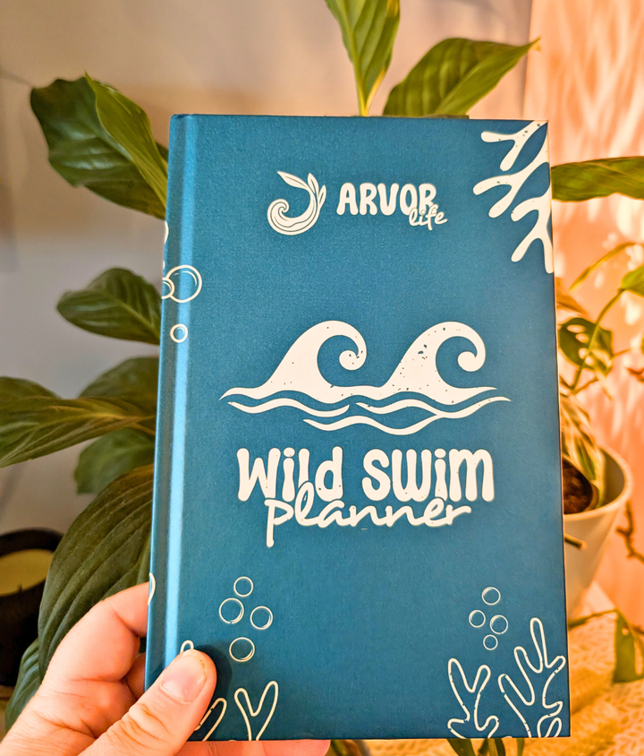 blue sea. design Hardback Wild Swim Planner open to weekly swim planning pages for wild swimmers.