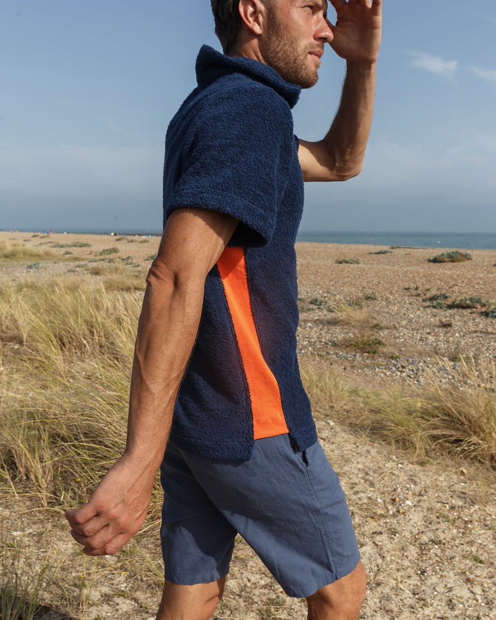So English Bond polo shirt in navy and orange, featuring a classic design with a collar and short sleeves.