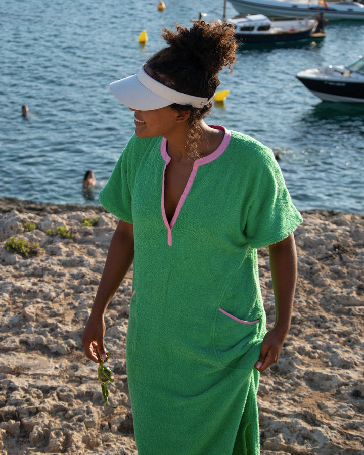 Long fresh green Kiss dress by So English, featuring a flowing design, shown on a model against a beach background.