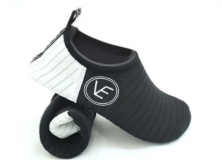 A pair of adult black and white recyclable water shoes and the VE Shoes logo on the side.