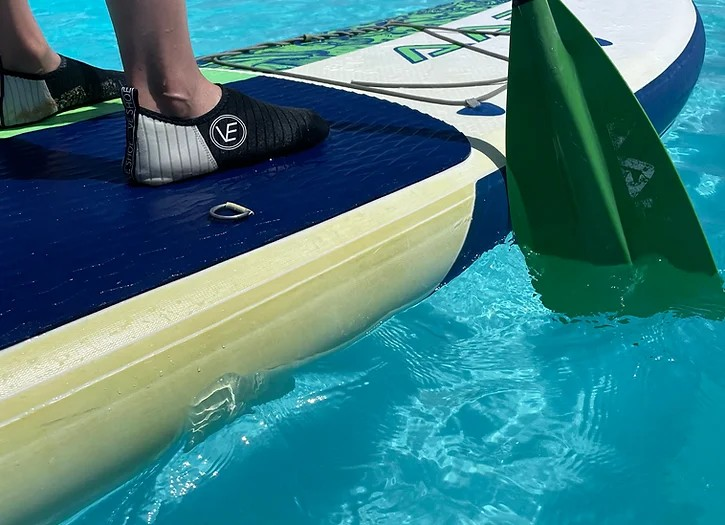 Image of black and white VE Shoe water shoes worn on a stand up paddle board
