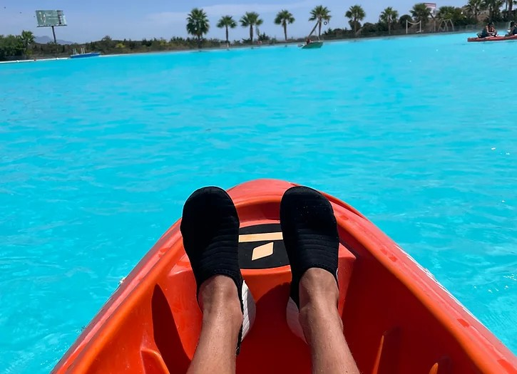Image of a person relaxing in a kayak wearing a pair of black water shoes