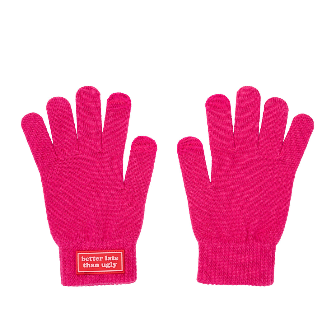 A flat shot of a pair of bright pink  gloves shown against a white background, with a red label on the cuff of the left glove that reads &