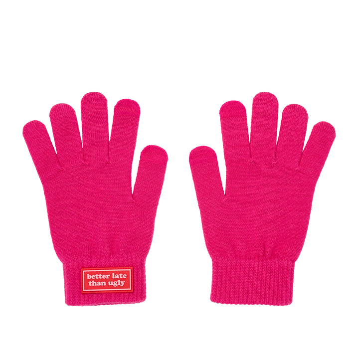 A flat shot of a pair of bright pink  gloves shown against a white background, with a red label on the cuff of the left glove that reads &