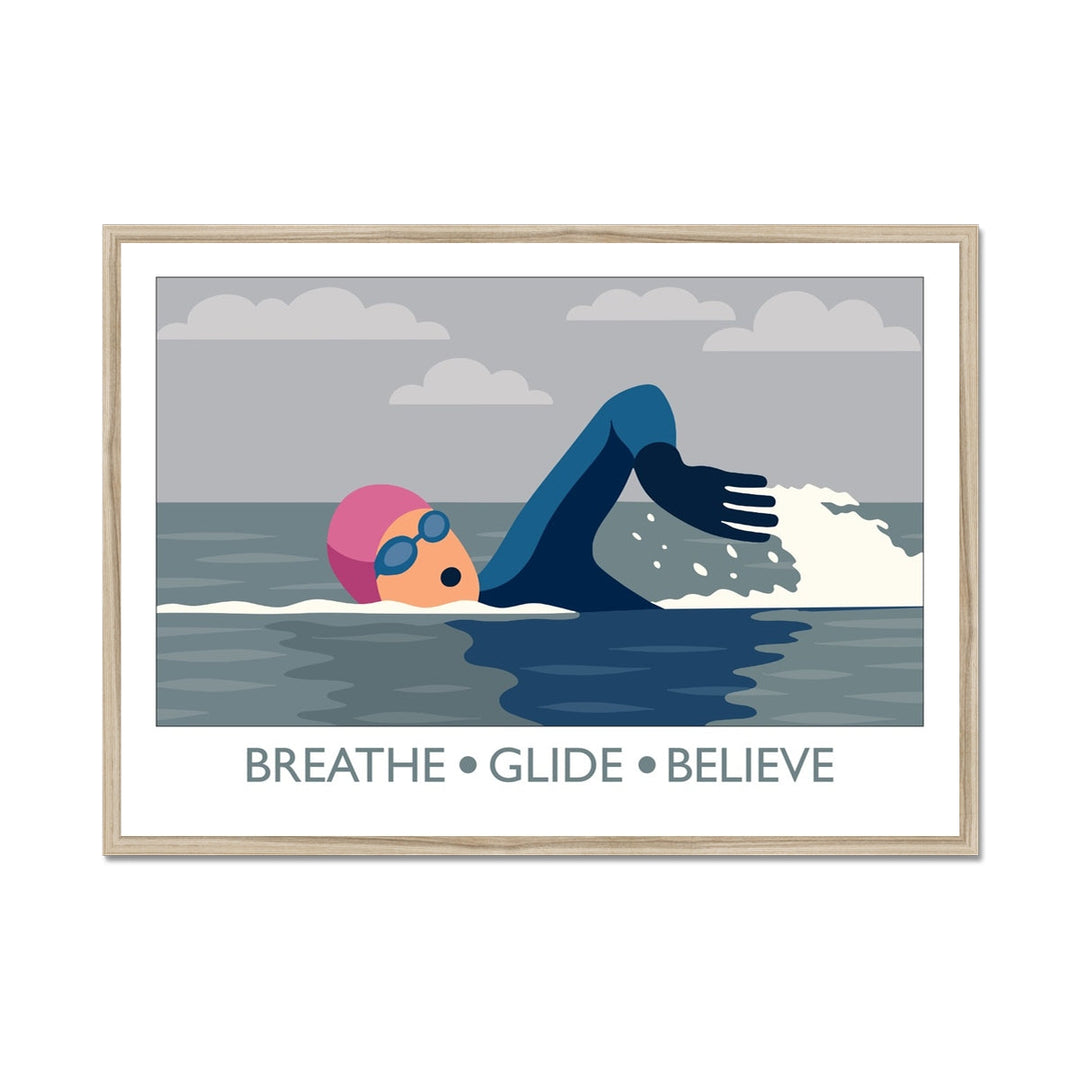 Framed wild swimming art print in a natural frame showing open water swimmer mid-stroke titled Breathe Glide Believe