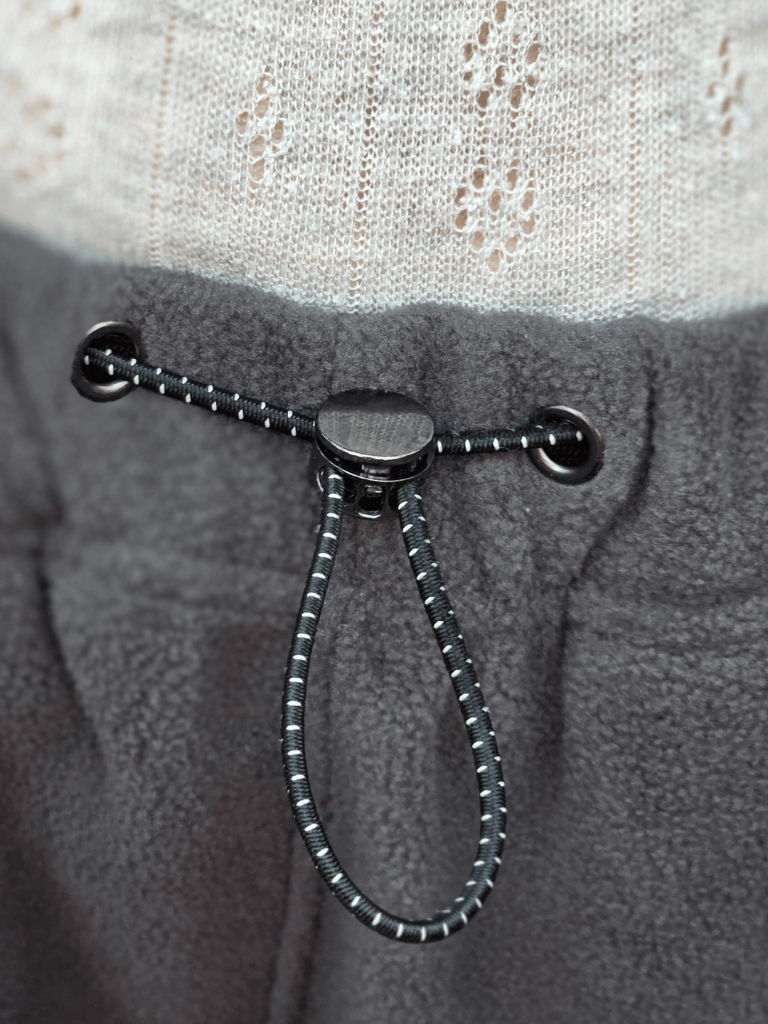 Close-up of a drawstring on grey fleece jogging pants