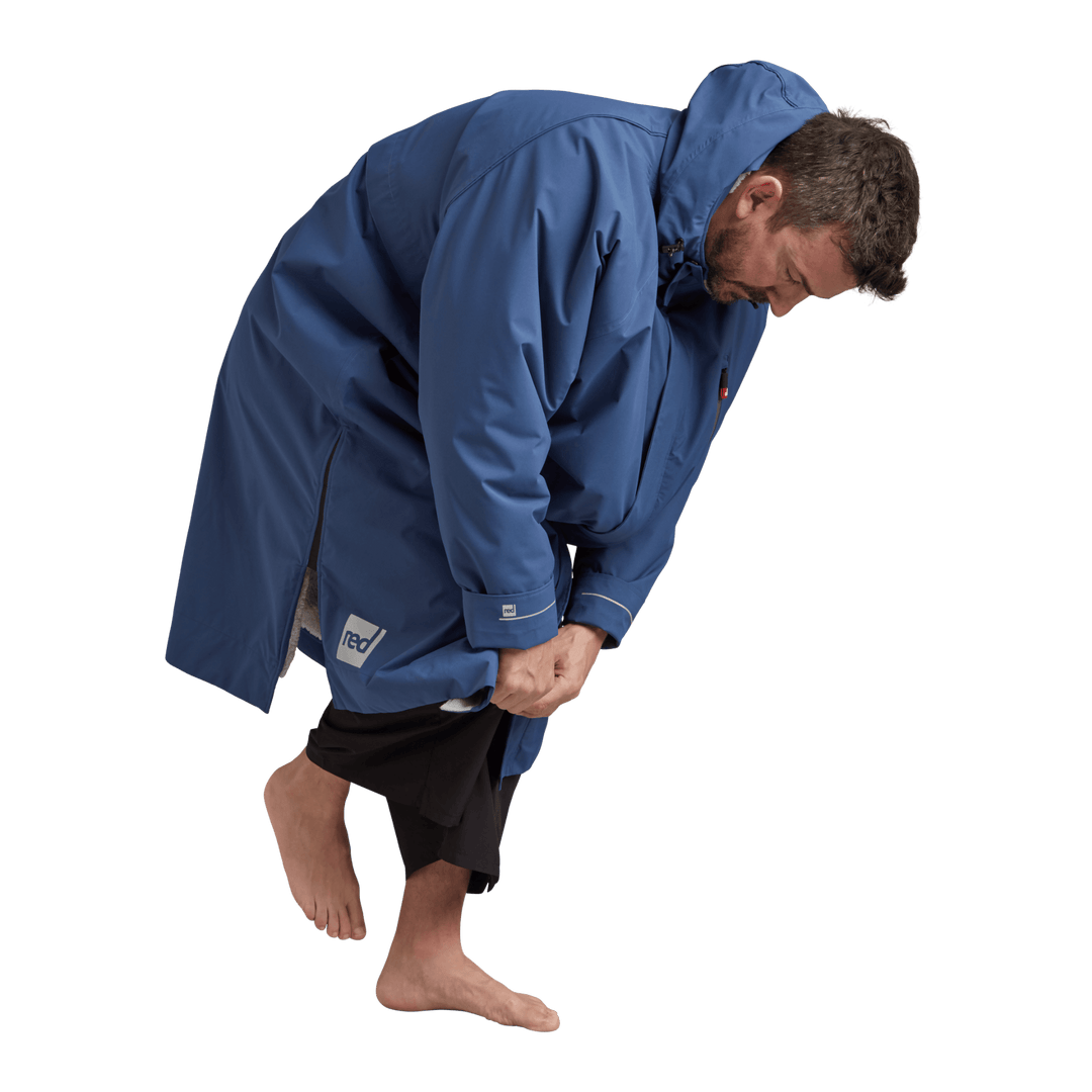 Side profile of a man changing underneath the Red Alter Evo men’s long sleeve waterproof changing robe in Admiral Blue.