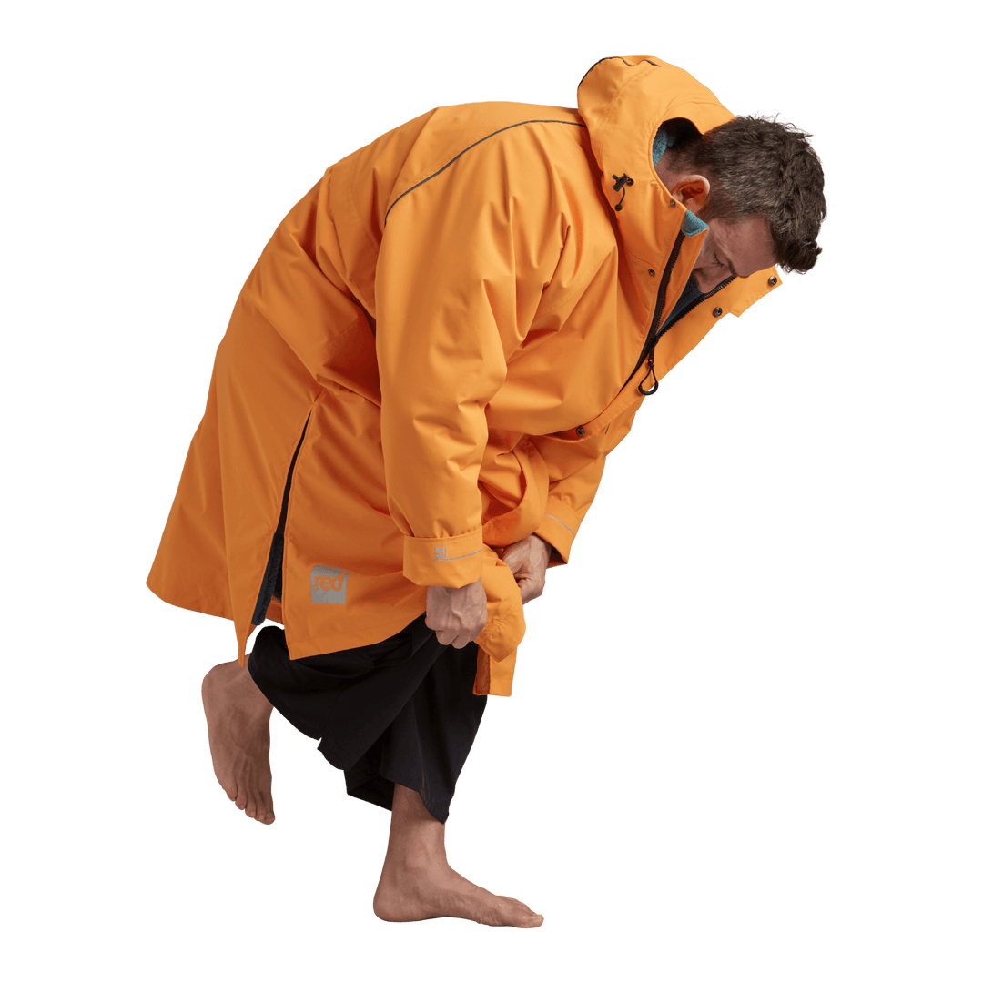 Side profile of a man changing underneath the Red Alter Evo long sleeve waterproof changing robe in Bitter Orange.