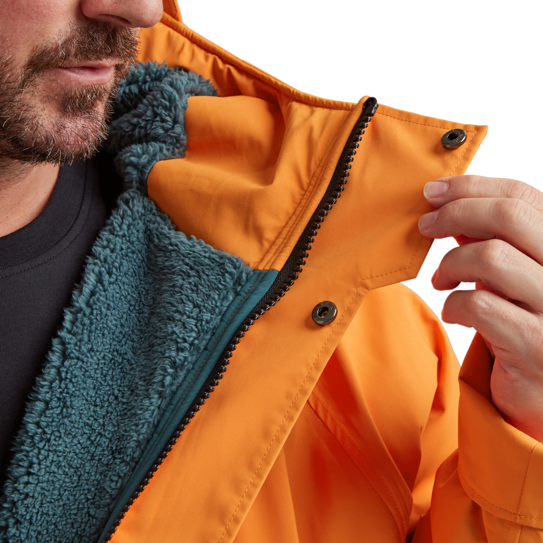 Two-way YKK zip with with easy-hold pulls and guard on Red Alter Evo men’s long sleeve waterproof changing robe in Bitter Orange.