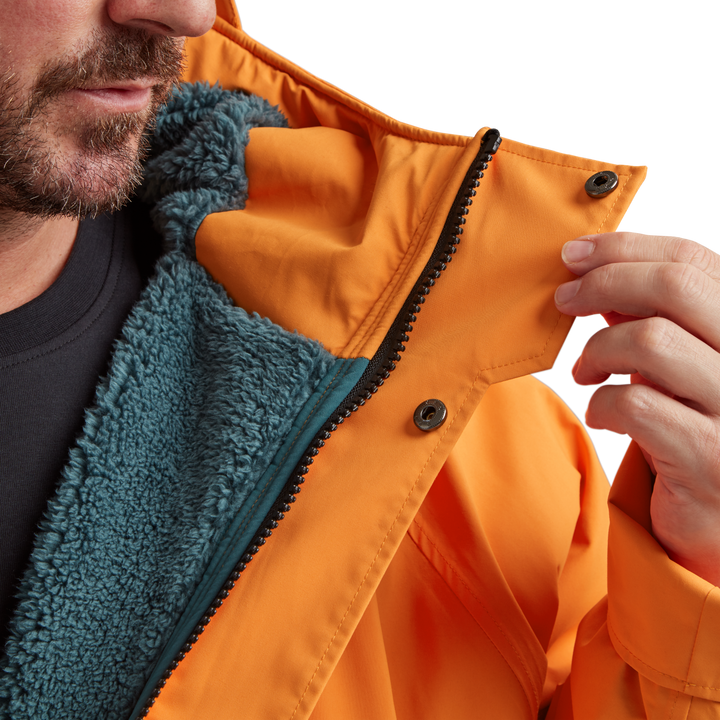 Two-way YKK zip with with easy-hold pulls and guard on Red Alter Evo men’s long sleeve waterproof changing robe in Bitter Orange.