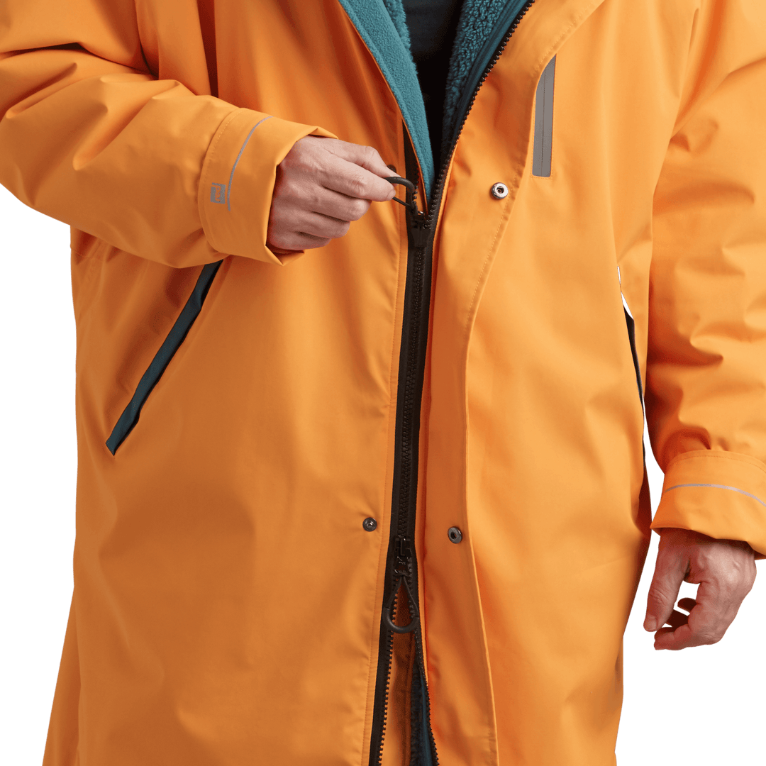 YKK two-way zip with easy-hold pulls on Red Alter Evo men’s long sleeve waterproof changing robe in Bitter Orange.
