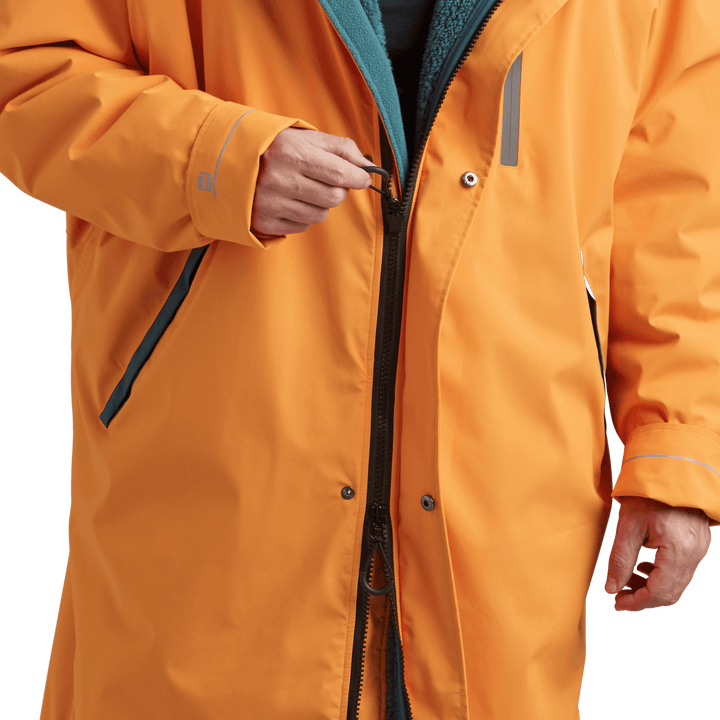 YKK two-way zip with easy-hold pulls on Red Alter Evo men’s long sleeve waterproof changing robe in Bitter Orange.
