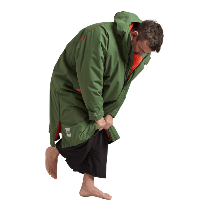 Side profile of a man changing underneath the Red Alter Evo long sleeve waterproof changing robe in Forest Green.