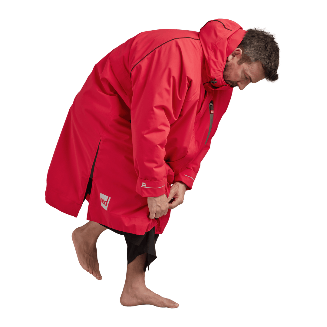 Side profile of a man changing underneath the Red Alter Evo long sleeve waterproof changing robe in Siren Red.
