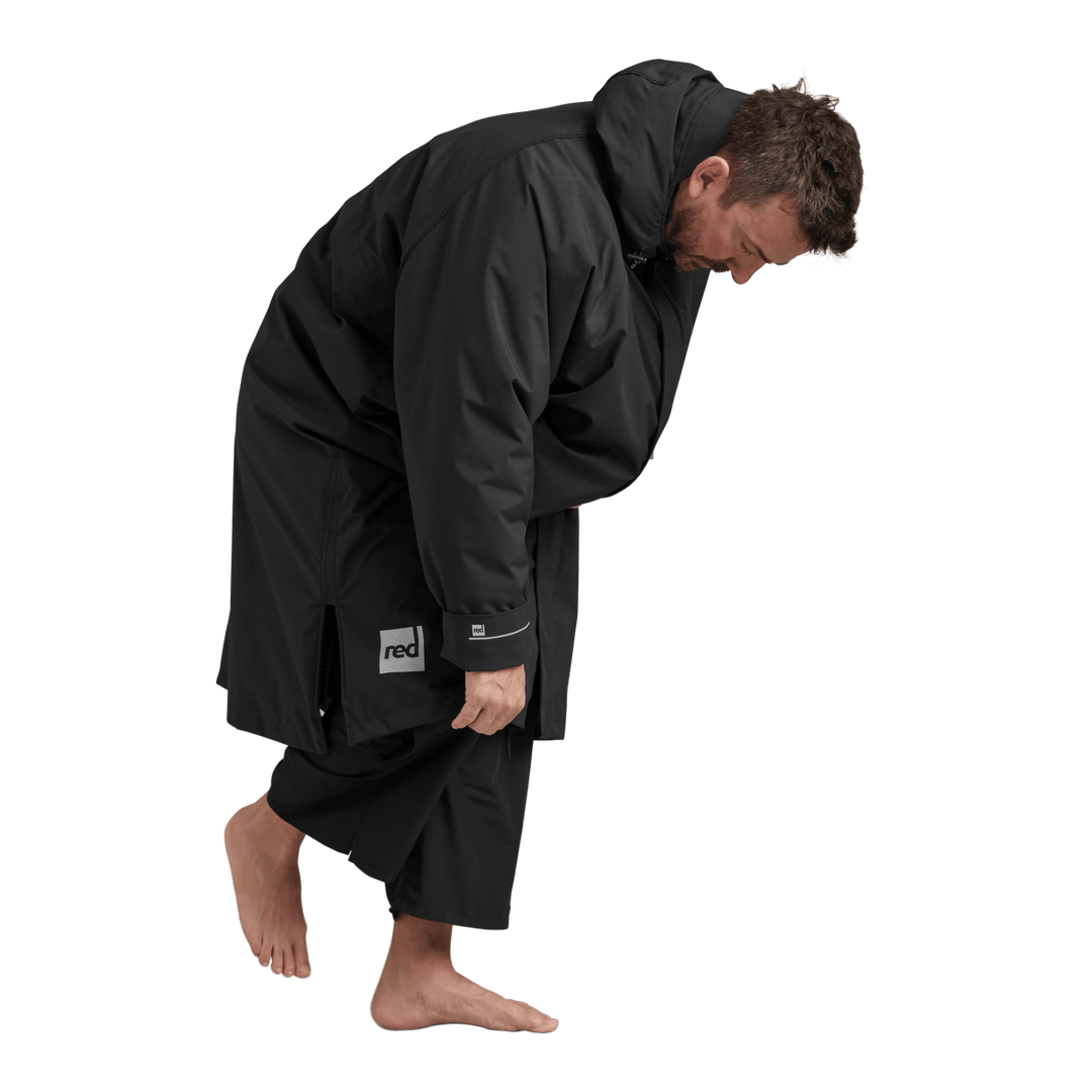Side profile of a man changing underneath the Red Alter Evo long sleeve waterproof changing robe in Stealth Black.