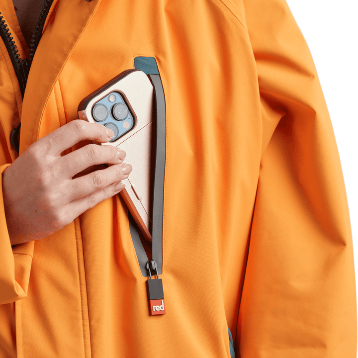 Waterproof chest pocket on Red Alter Evo women’s long sleeve waterproof changing robe in Bitter Orange, ideal for storing your mobile phone.