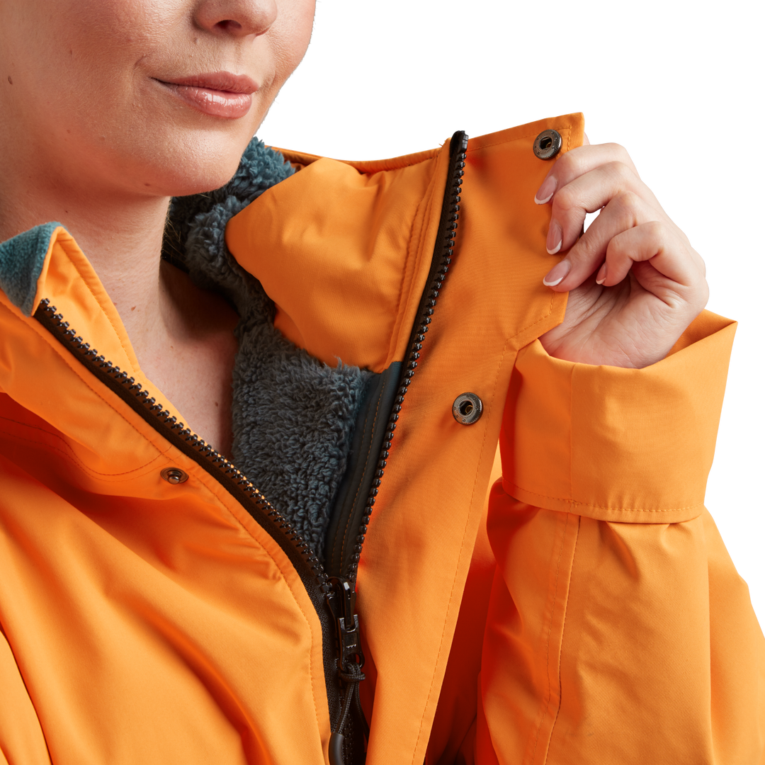 Two-way YKK zip with with easy-hold pulls and guard on Red Alter Evo women’s long sleeve waterproof changing robe in Bitter Orange.