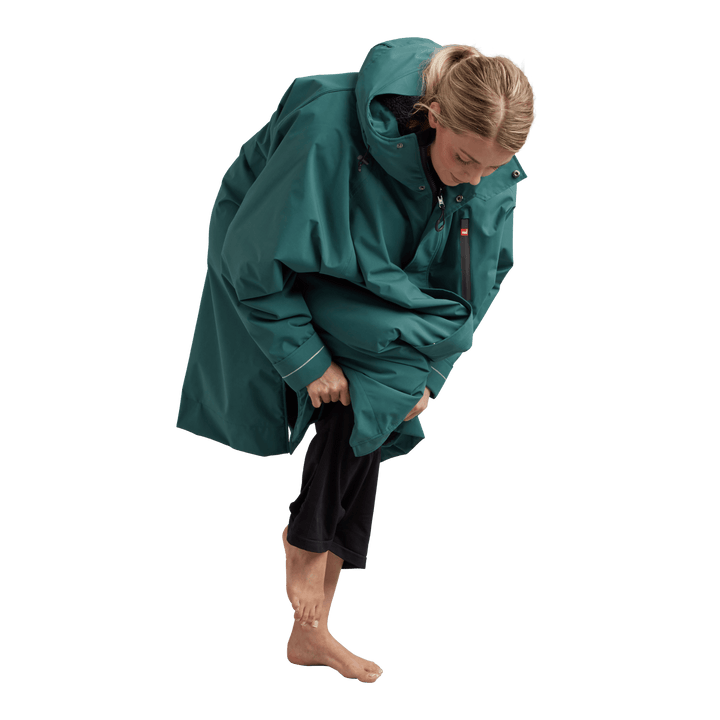Side profile of a woman changing underneath the Red Alter Evo long sleeve waterproof changing robe in Deep Teal.