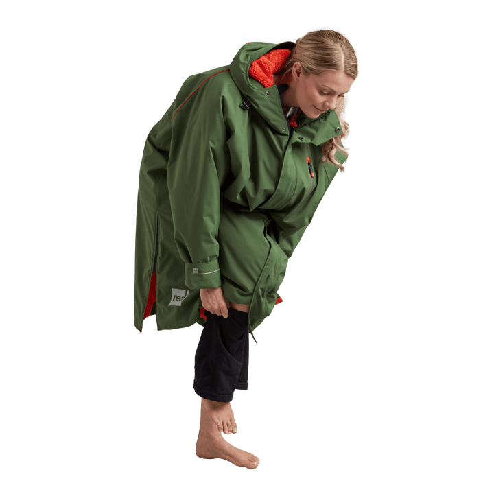 Side profile of a woman changing underneath the Red Alter Evo long sleeve waterproof changing robe in Forest Green.