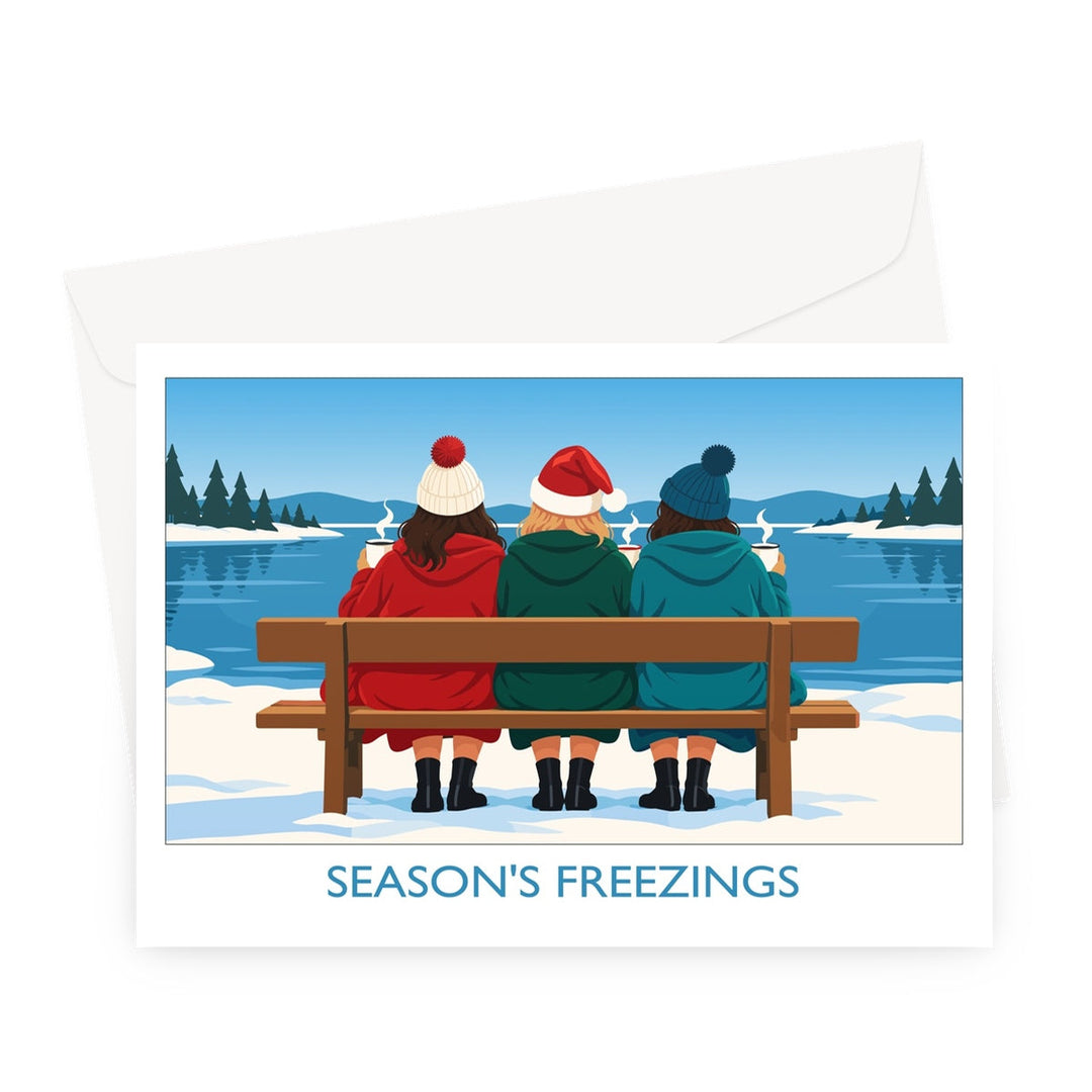 Season's Freezings wild swimming Christmas card by Wild Swim Studio featuring three friends in winter hats enjoying hot drinks beside a snowy lake