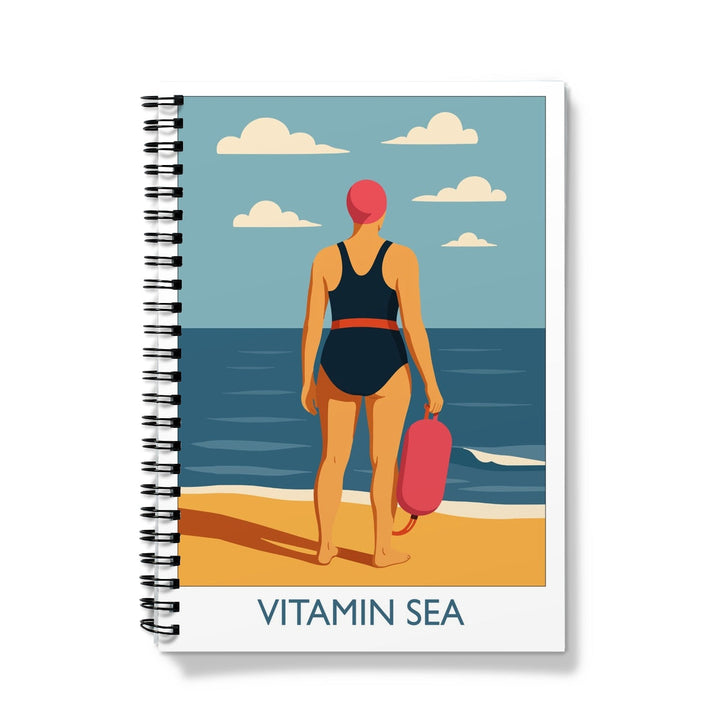 Wild swimming notebook featuring Vitamin Sea artwork with swimmer standing at the shoreline holding a tow float
