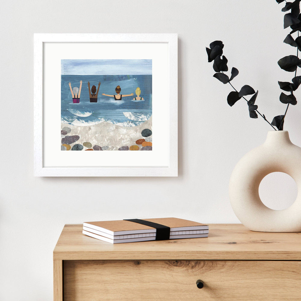 Wild Sea Swimmers art print displayed in a white frame in a contemporary home setting.