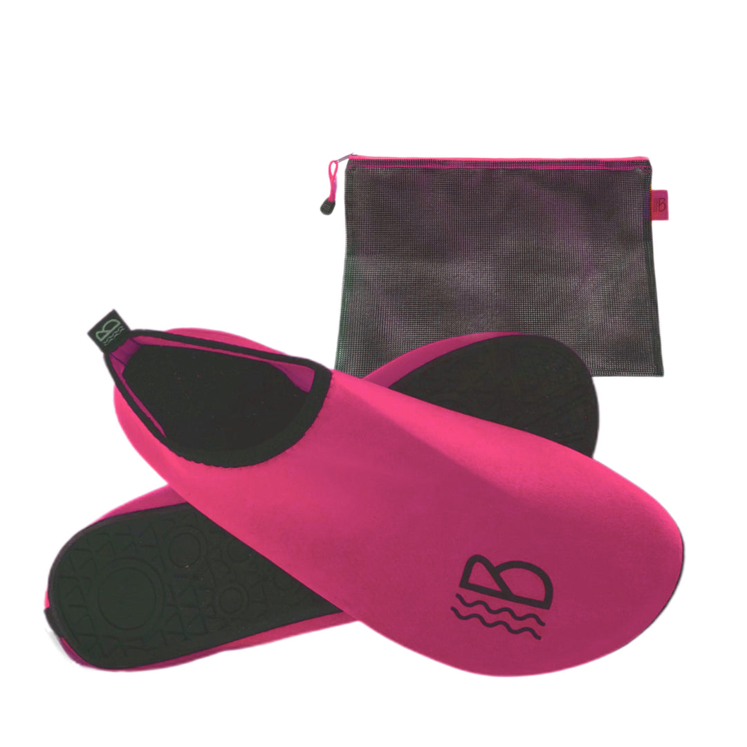 A pair of pink water shoes with a black breathable mesh storage bag.