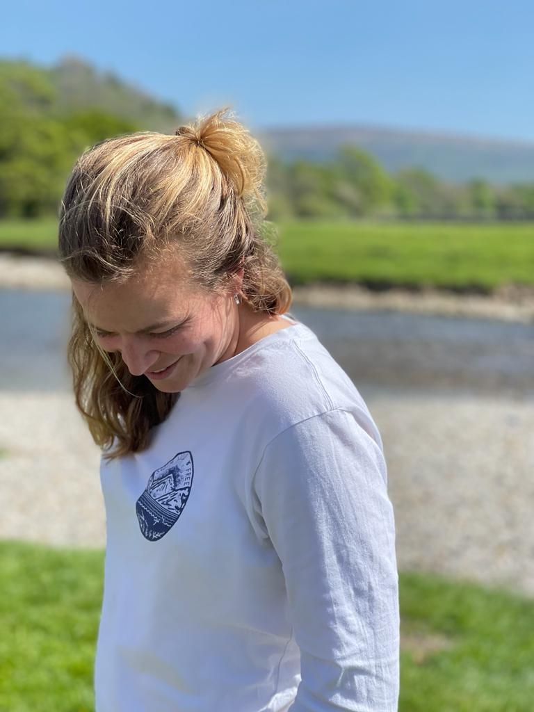 Side view of the Hannah Hunter Kelm white long-sleeve t-shirt with a design based on one of Hannah's original linocut prints of a swim across Wastwater in the Lake District